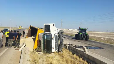 Kum yüklü kamyon refüje devrildi