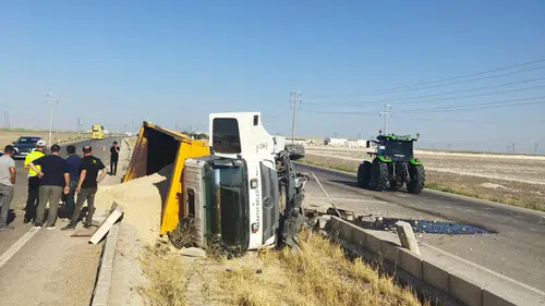 Kum yüklü kamyon refüje devrildi