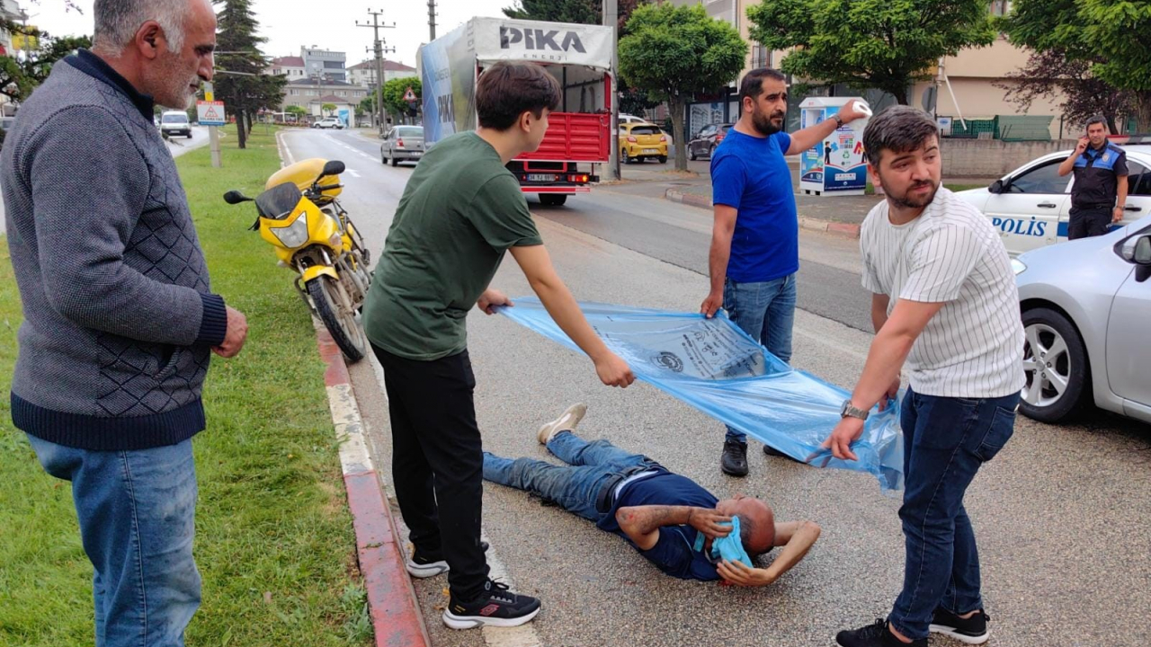Kazada yaralanan PTT memurunu yağıştan çöp poşetiyle korudular
